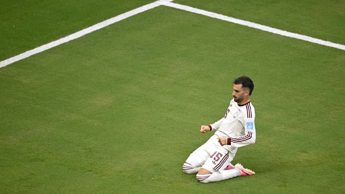 Игрок на коленях на футбольном поле после гола