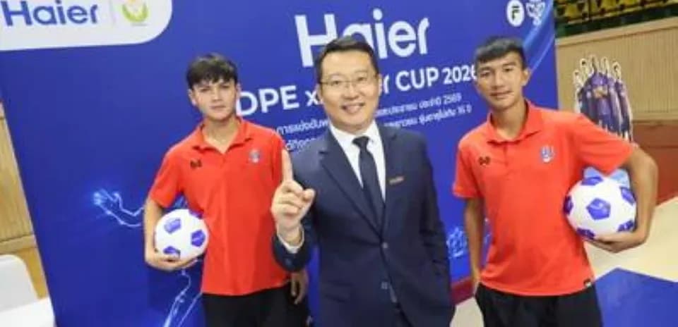 Трое людей на фоне рекламного щита Haier
