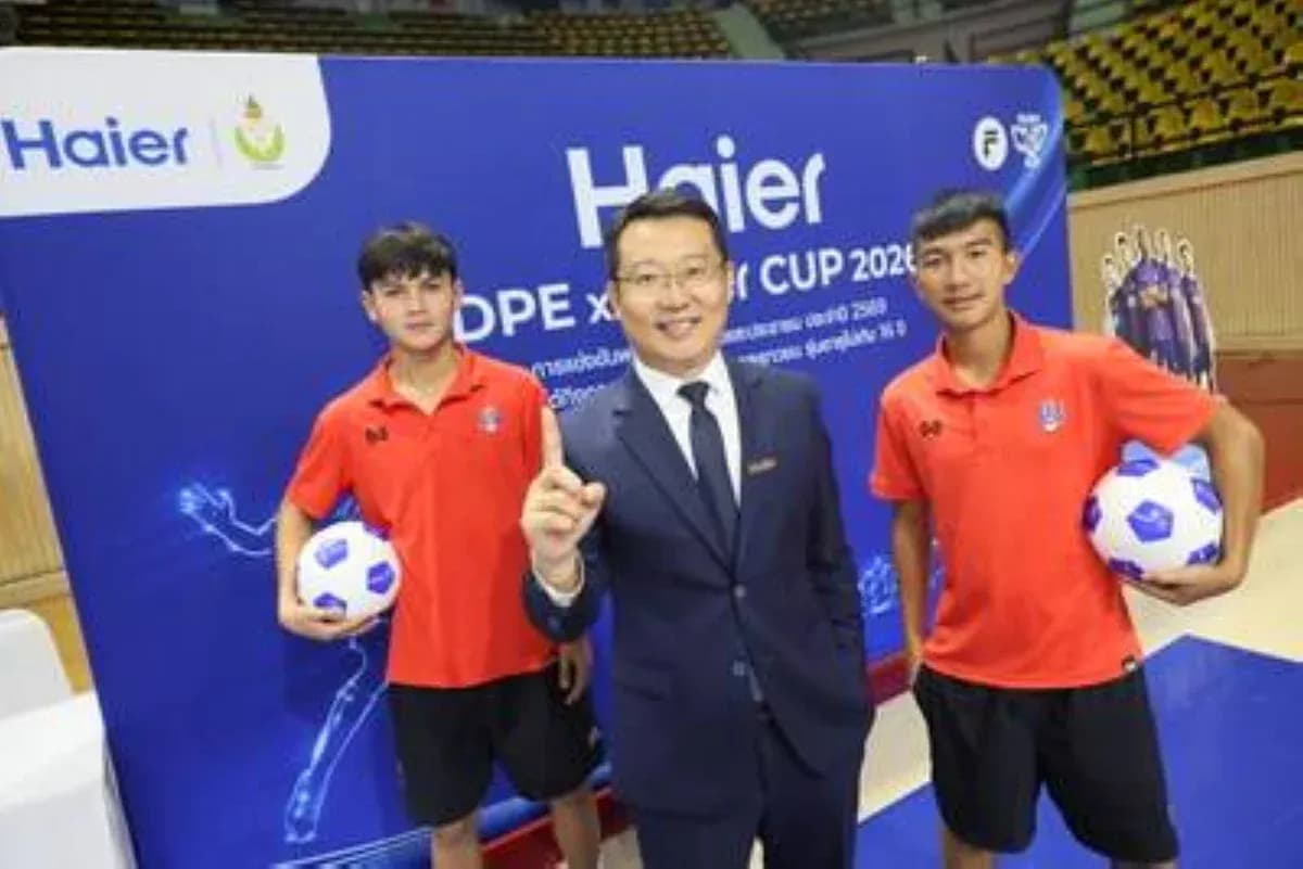 Трое людей на фоне рекламного щита Haier