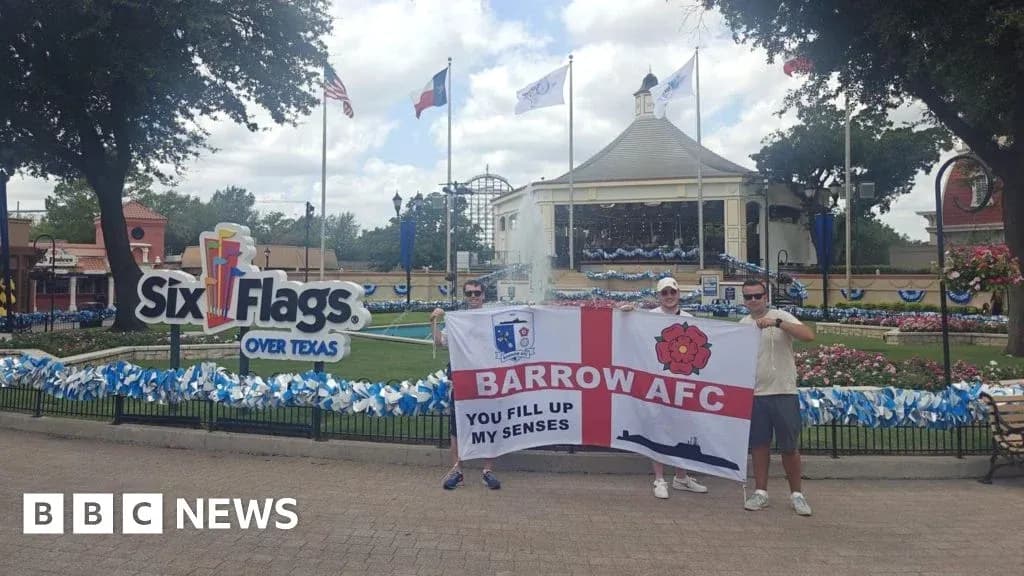Два человека с флагом Barrow AFC у Six Flags
