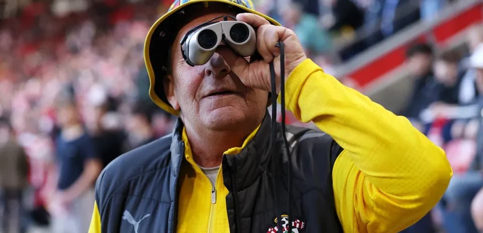 Болельщик с биноклем на стадионе