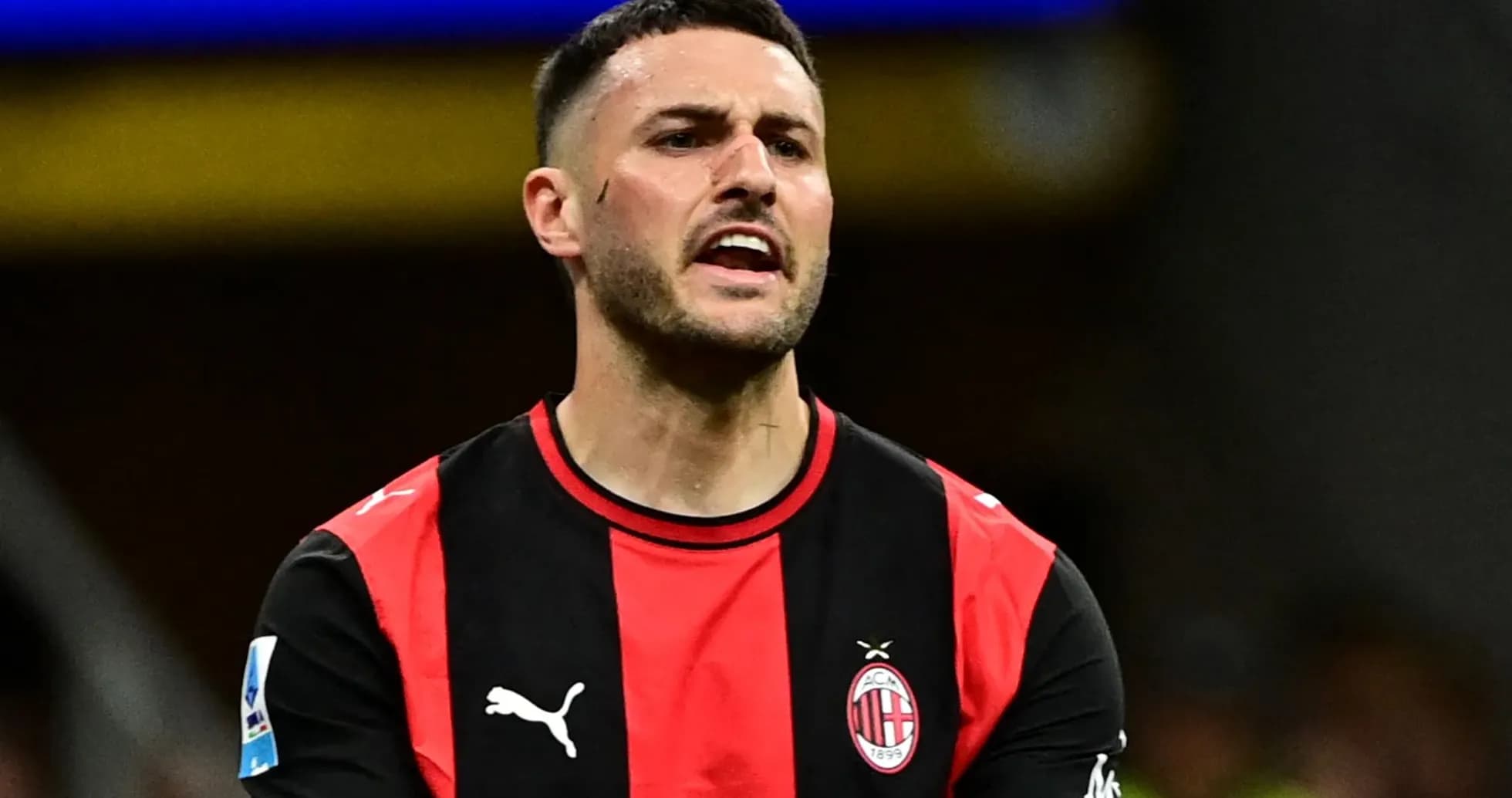 Игрок AC Milan в черно-красной форме на поле Игрок AC Milan в черно-красной форме на поле